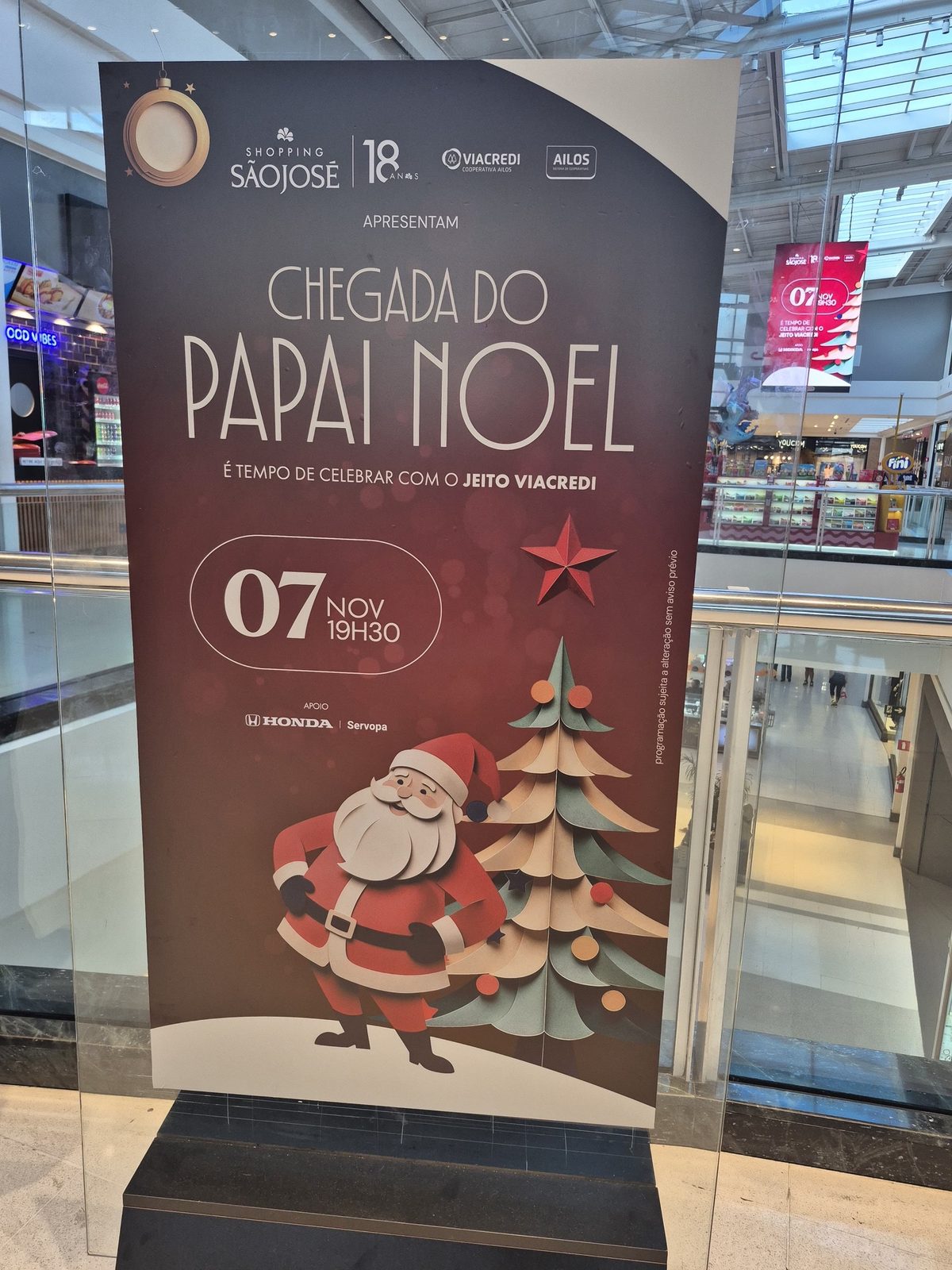 Totem da Chegada do Papai Noel no mall, com o telão de LED ao fundo